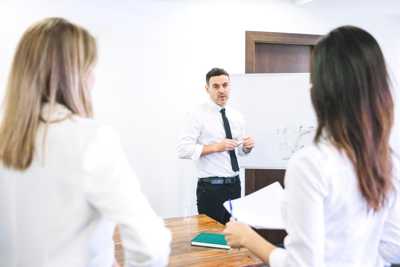 Salle de formation avec analystes financiers travaillant sur des modèles Excel